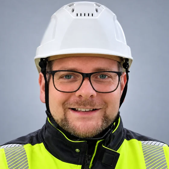 Porträt von Christian Engelke mit weißem Schutzhelm und Warnjacke